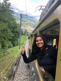 Amy Paul leaning out the window of a trolley giving a thumbs up